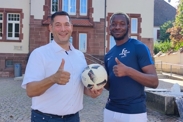 Foto v.l.n.r.: Brgermeister Markus Hollemann und Christian Onuchukwu, der einen Fuball in seiner Hand hlt