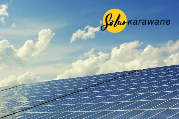 Photovoltaikanlage, blauer Himmel mit vereinzelten Wolken, Logo Solarkarawane