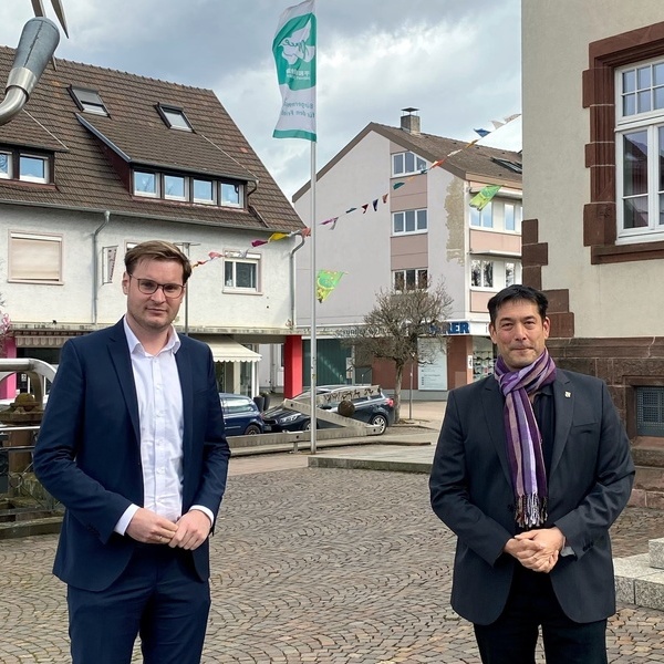 MdB Yannick Bury und Brgermeister Markus Hollemann vor der Flagge "Mayors for Peace"