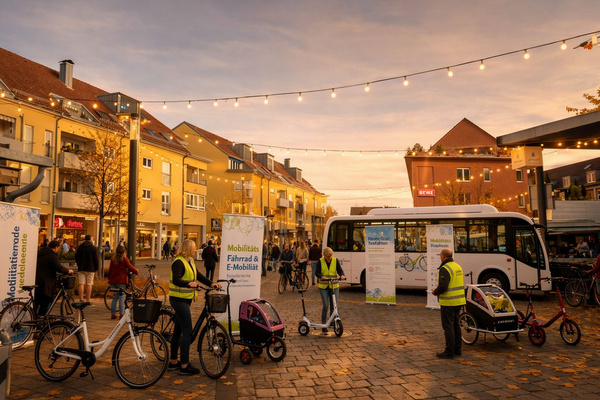Ortsmitte mit Marktständen, BesucherInnen, diverse Fahrräder und ein Bus Ortsmitte mit Marktständen, BesucherInnen, diverse Fahrräder und ein Bus